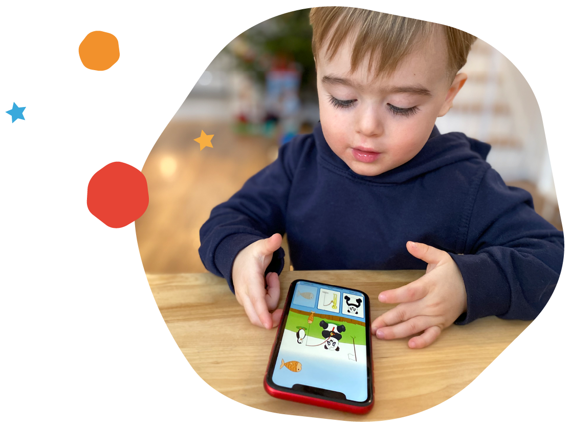 Jeune enfant jouant à l'appli OrthoPicto sur un téléphone posé sur la table
