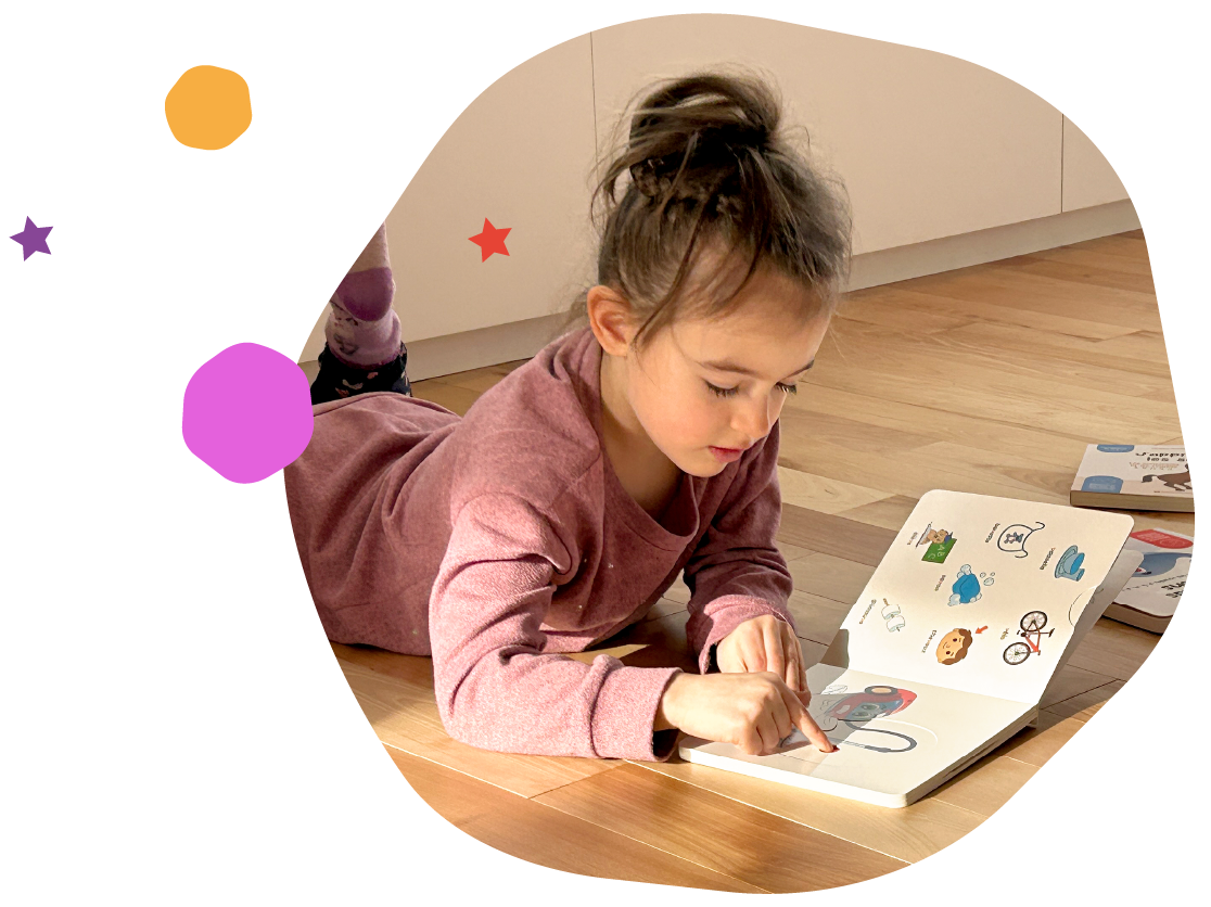 Young boy playing on the floor with a magnetic box set full of magnetic pictograms