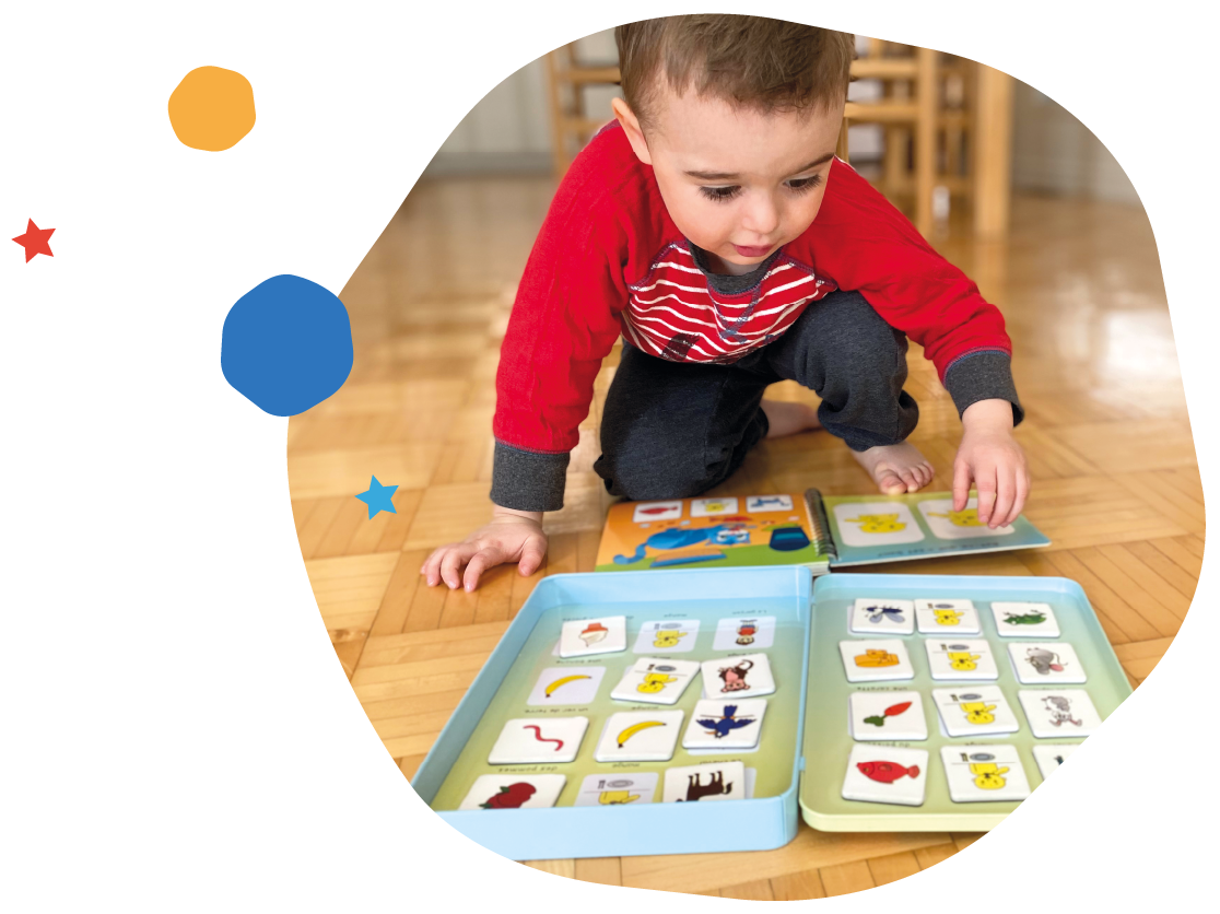 Girl lying on the floor, absorbed in her open magnetic vocabulary book in front of her